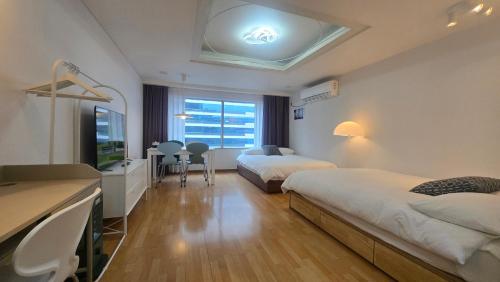 a hotel room with two beds and a flat screen tv at Paradise Hongdae in Seoul