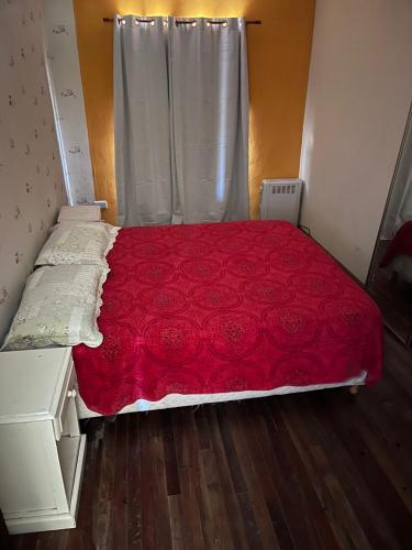a bed with a red bedspread in a room at Natural Hostel Colon in Colón