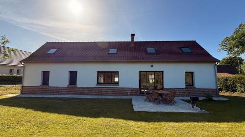 a small white house with a table and chairs at Magnifique gite ambiance chalet in Arrest