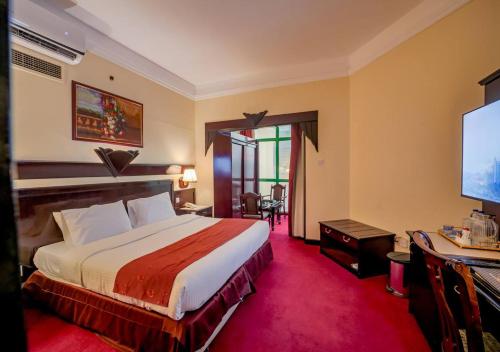 una habitación de hotel con cama y televisor de pantalla plana en Claridge Hotel, en Dubái