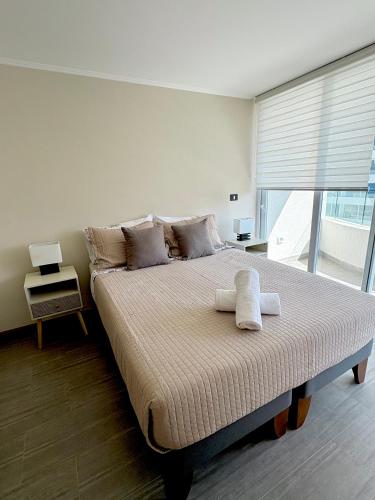 Nuevo departamento en peninsula- cavancha في إكيكي: غرفة نوم بها سرير كبير عليه منشفتين