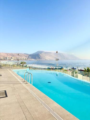 Nuevo departamento en peninsula- cavancha في إكيكي: حمام سباحة مع إطلالة على المحيط