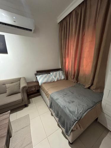 ドーハにあるStudio Studioのベッドとソファと窓のある寝室