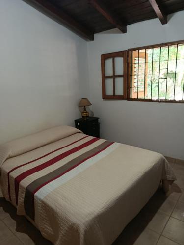 a bedroom with a bed and a window at Das Kleine Nest in Villa General Belgrano