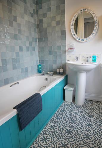 a bathroom with a bath tub and a sink at Holmlea Cottage in Freuchie
