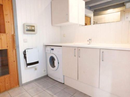 a white kitchen with a washing machine in it at Ferienhaus im skandinavischen Stil in Granzow