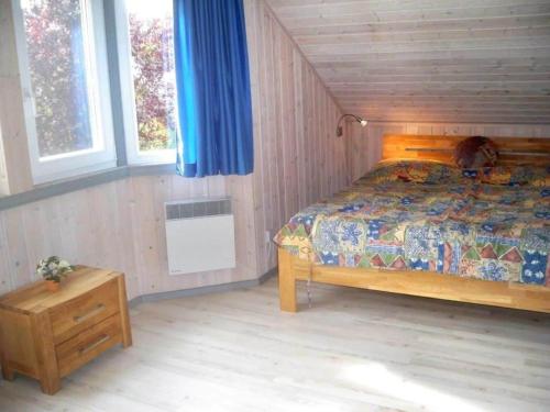 a bedroom with a bed and a table and windows at Ferienhaus im skandinavischen Stil in Granzow