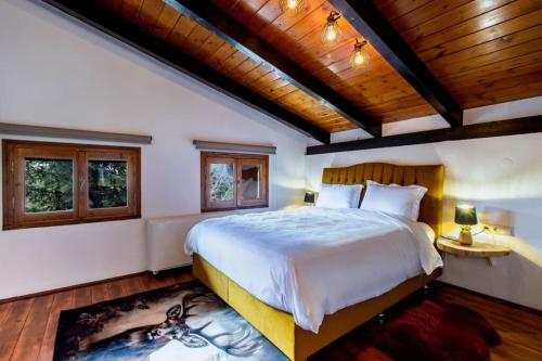 Un dormitorio con una cama grande y un techo de madera. en MZ Reindeer, en Kalívia