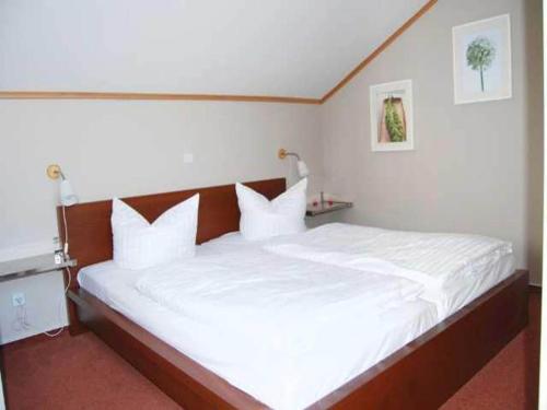 a bedroom with a large bed with white sheets and pillows at Apartment für den perfekten Urlaub in Granzow