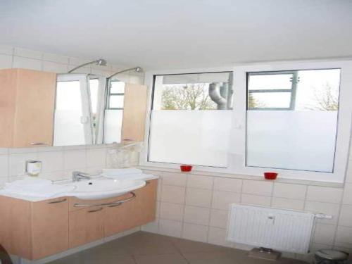 a bathroom with a sink and two windows at Apartment für den perfekten Urlaub in Granzow