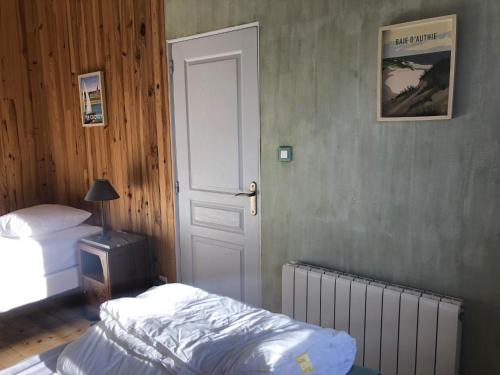a bedroom with a bed and a door with a radiator at Petite maison à la mer in Fort-Mahon-Plage