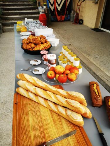 een tafel met verschillende soorten brood en andere voedingsmiddelen bij Camping Le Coin Charmant in Chauzon