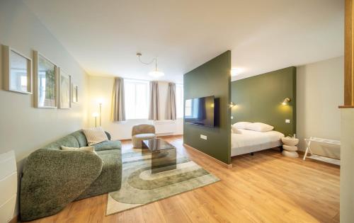 una sala de estar con un sofá y una cama en Le Splendide, en Mâcon