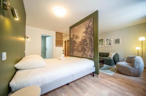 Un dormitorio con una cama, un sofá y una silla. en Le Splendide, en Mâcon