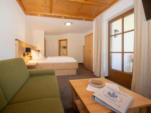 pokój z łóżkiem, kanapą i stołem w obiekcie Hof Unterhuben w mieście Fügenberg