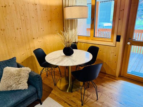a living room with a table with chairs and a couch at Mellau Apartments in Mellau