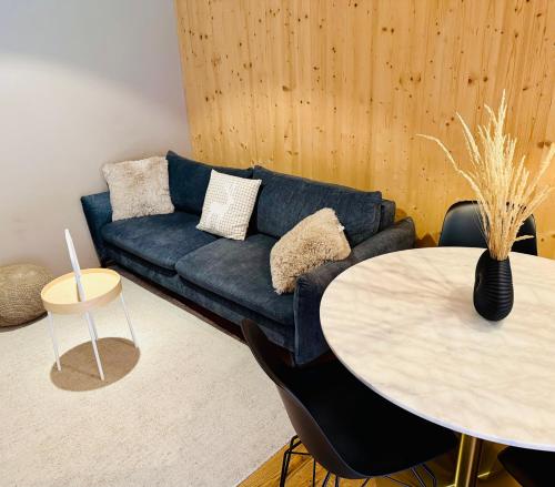a living room with a blue couch and a table at Mellau Apartments in Mellau