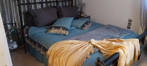 a bedroom with a bed with blue sheets and pillows at Ariadnis Apartment in Artemida