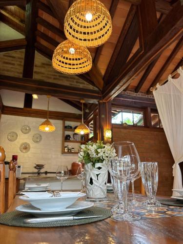 a dining room table with glasses and plates and lights at Guest House Tânia Alves in Pratinha