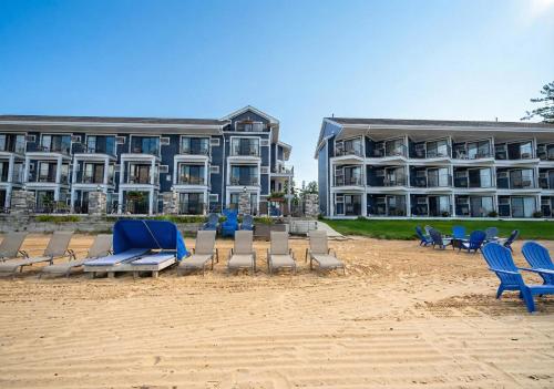 a beach with chairs and a large building at Pointes North Beachfront Hotel - 2 Person Spa Tub Studios in Traverse City