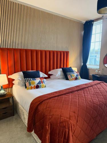 a bedroom with a large bed with a red headboard at The courtyard bar, kitchen, rooms in Falkirk