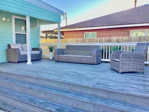 a porch with two wicker chairs on a house at Urban Aquarium Home for 8 in Galveston