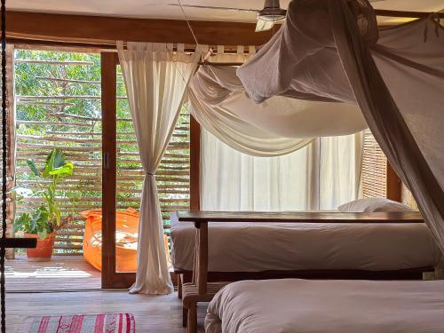 a bedroom with two beds and a window at Eco Lodge Mancora in Máncora