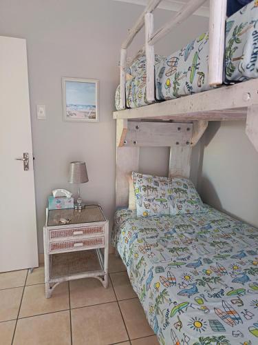 a bedroom with a bunk bed and a night stand at Hartenbos - Bayview 230m from beach in Mossel Bay