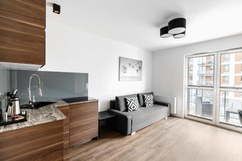 un soggiorno con un divano e una finestra di Apartamenty Platinex 2 a Cracovia