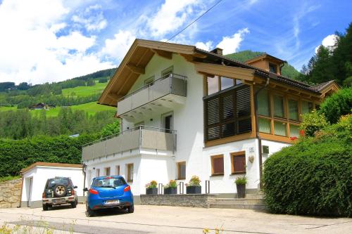 a blue car parked in front of a house at Ferienwohnung Schachner in Heiligenblut