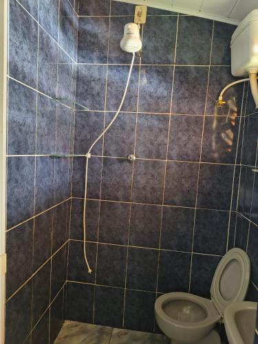 a bathroom with a toilet and a shower at Chalé da Elba 01 Ilhabela in Ilhabela