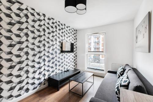 un soggiorno con divano e parete geometrica di Apartamenty Platinex 2 a Cracovia