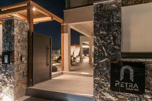 a entrance to a house with a stone wall at Brand new Petra Luxuria Villa with private pool in Prasás