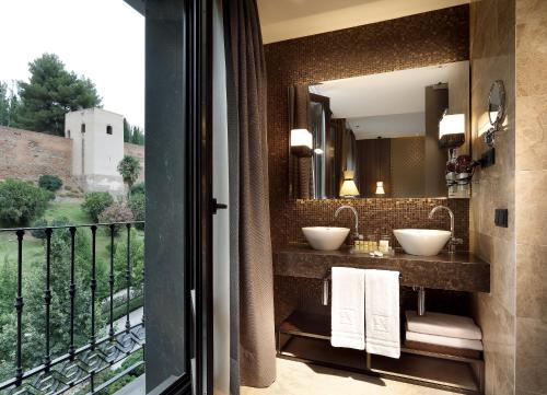 
a bathroom with a large mirror and a large window at Áurea Washington Irving by Eurostars Hotel Company in Granada
