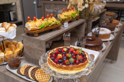 a buffet with a cake with fruit on top and pastries at Concept Hotel Flat in Balneário Camboriú