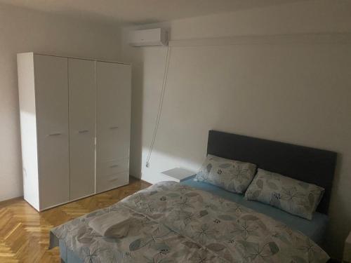a bedroom with a bed and a white cabinet at SaS in Vrbas