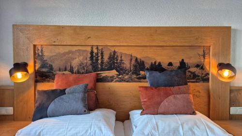 a bedroom with two beds and a painting on the wall at Hotel Dahoam by Miha in Westendorf