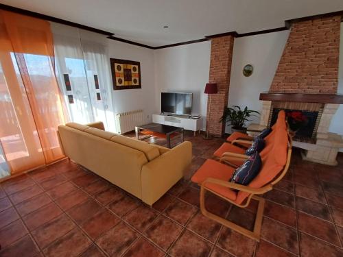 Villa Tiviti في أوفِييذو: غرفة معيشة مع أريكة وكراسي وتلفزيون