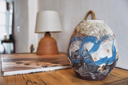 Casa Al Zaytun Pueblo في Canillas de Aceituno: وجود مزهرية على طاولة بجانب مصباح