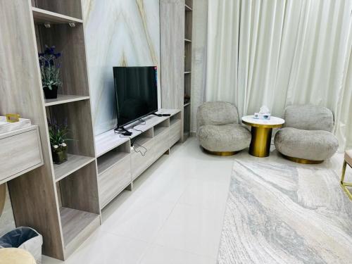 Una sala de estar con dos sillas y un televisor. en The home 4, en Sharm