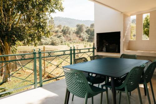 a black table and chairs on a balcony with a view at Patryssenvalleij Farm and Cottages in Stellenbosch