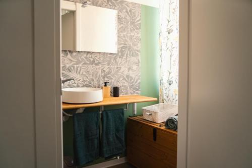 ein Badezimmer mit einem Waschbecken und einer Holztheke in der Unterkunft Moderno Rifugio - Milano Rogoredo in Mailand