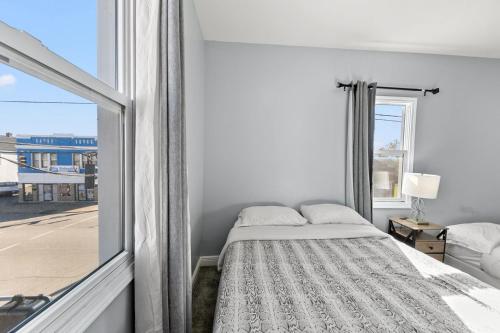 een witte slaapkamer met een bed en een raam bij Cozy 3BR Home • Smart TV + Workspace in Dayton