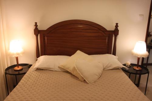 a bed with two lamps and two pillows on it at Memórias in Nogueira da Regedoura