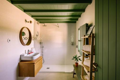 ein Badezimmer mit Waschbecken, Dusche und Spiegel in der Unterkunft Vila Coura in Amarante