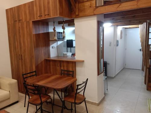 a dining room with a wooden table and chairs at Front beach cosy apartment in La Goulette