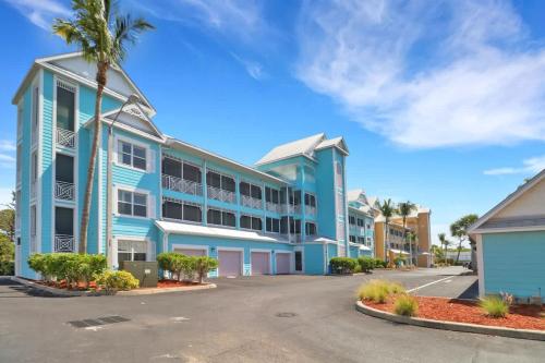 un edificio azul con una palmera delante de él en NEW Condo near beach Ideal for Remote Work, en Bonita Springs