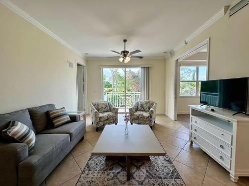 Una sala de estar con un sofá y un televisor. en NEW Condo near beach Ideal for Remote Work, en Bonita Springs