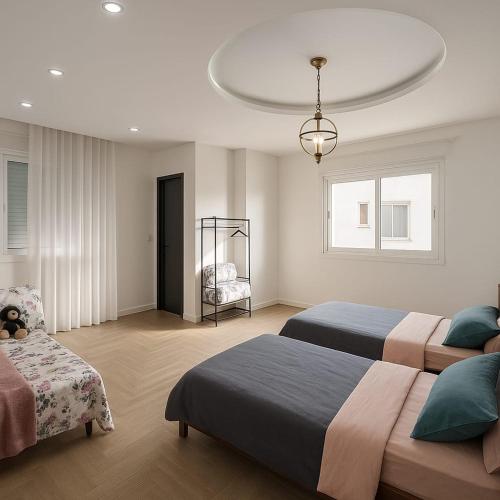 a bedroom with two beds and a chandelier at Jolie appartement avec terrasse in Reghaïa