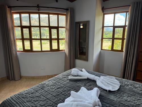 a bedroom with towels on a bed with a window at Shumaq Guesthouse in Carhuaz